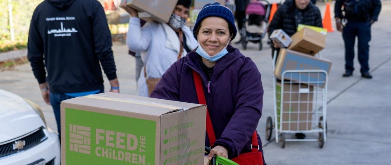 A woman outdoors with boxes at an event