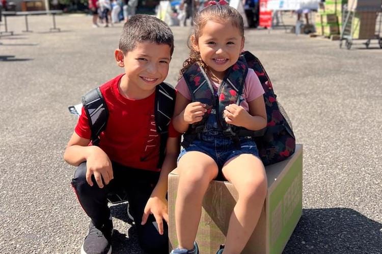 Two children at an outdoor event smiling