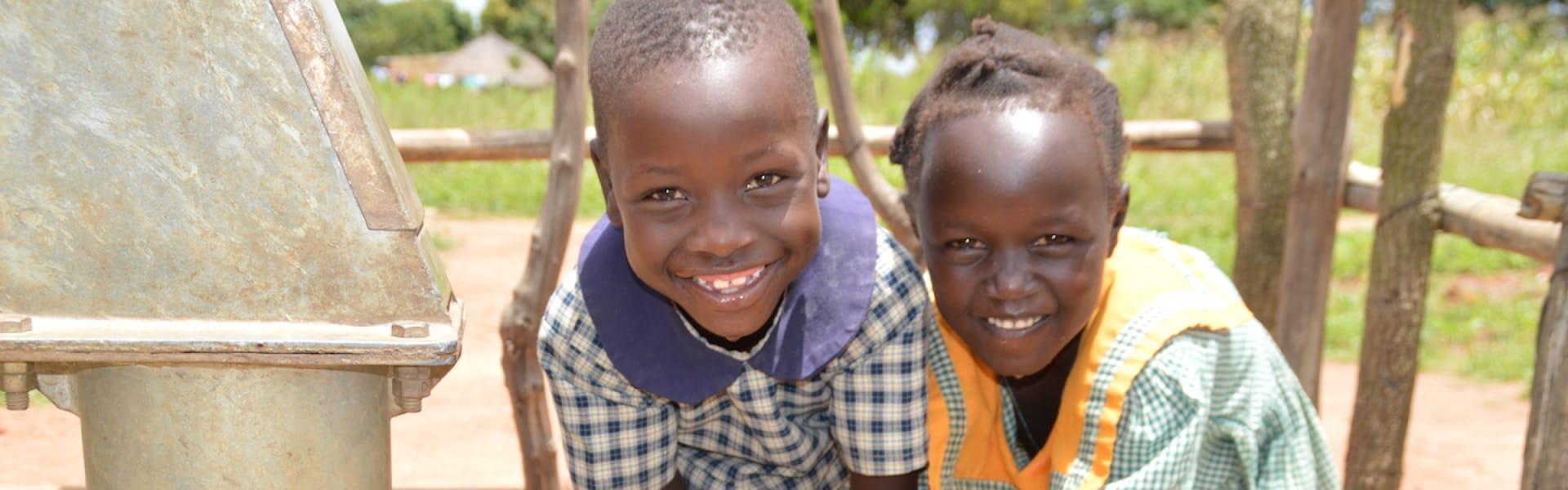 Two children smiling while outdoors