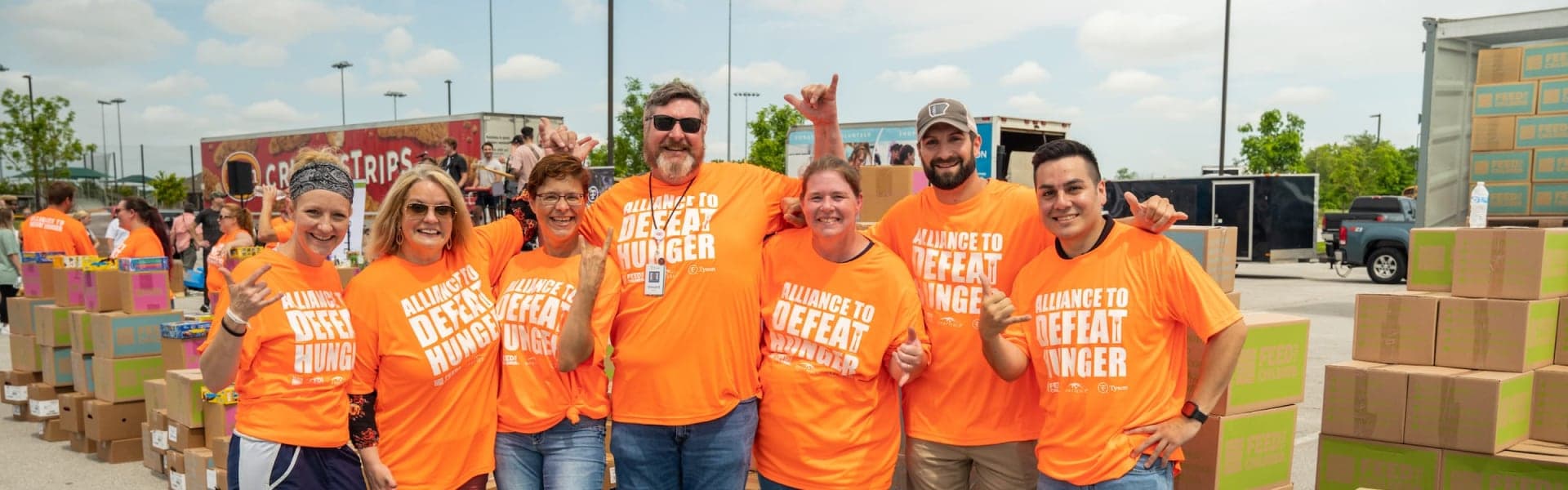 A group of volunteers standing together at a box event outdoors