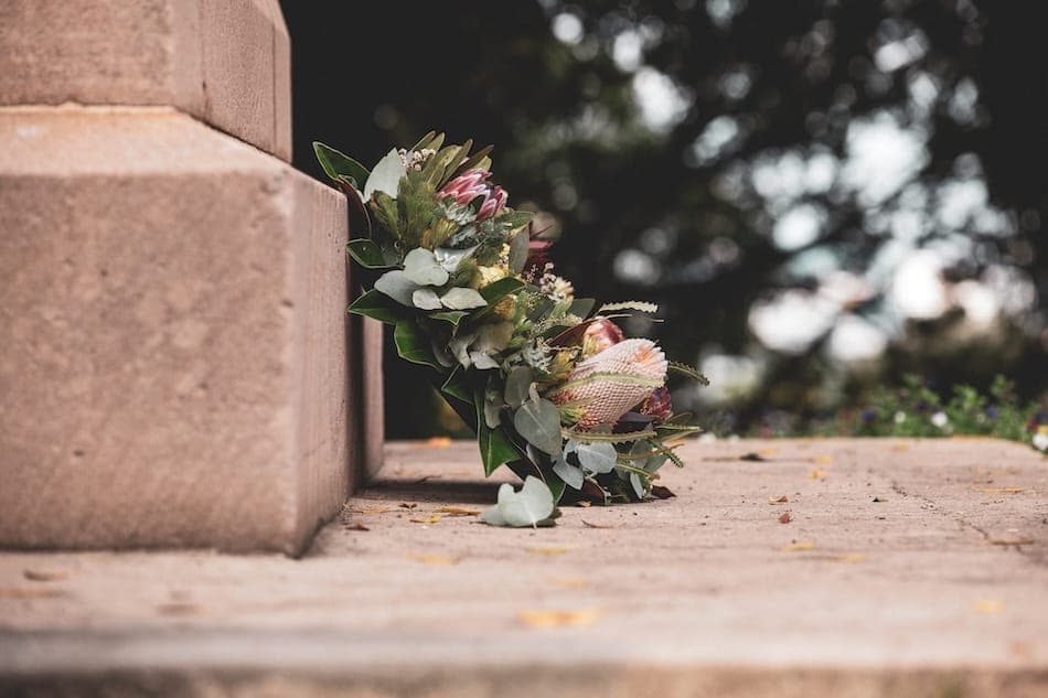 A wreath of flowers sitting against bricks