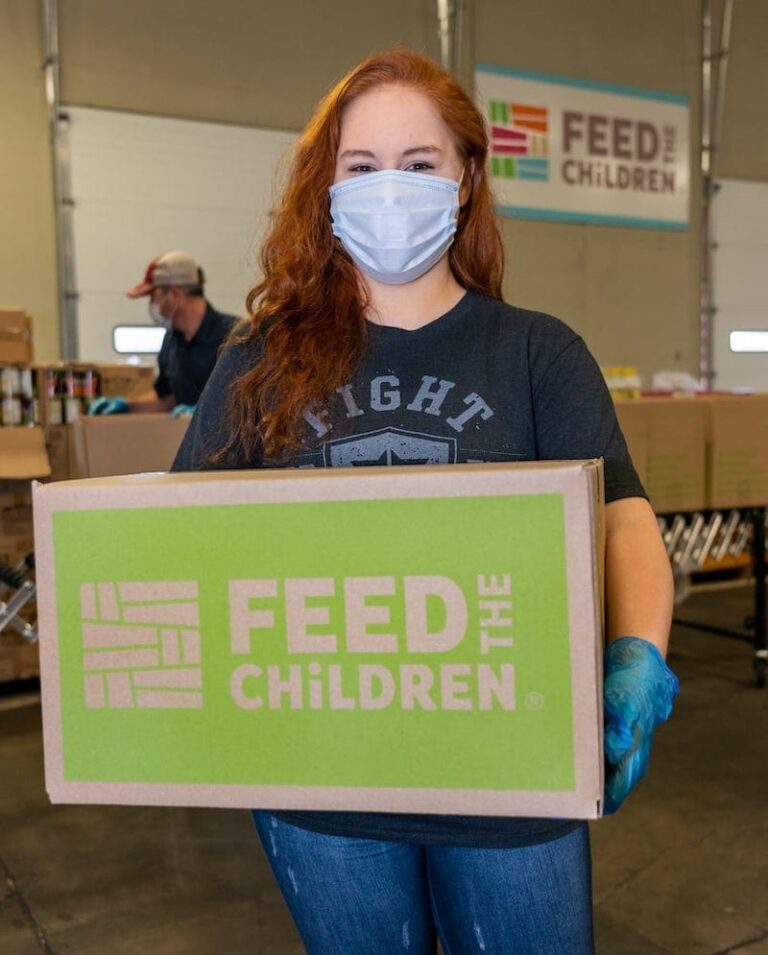 A volunteer holding a Feed the Children box