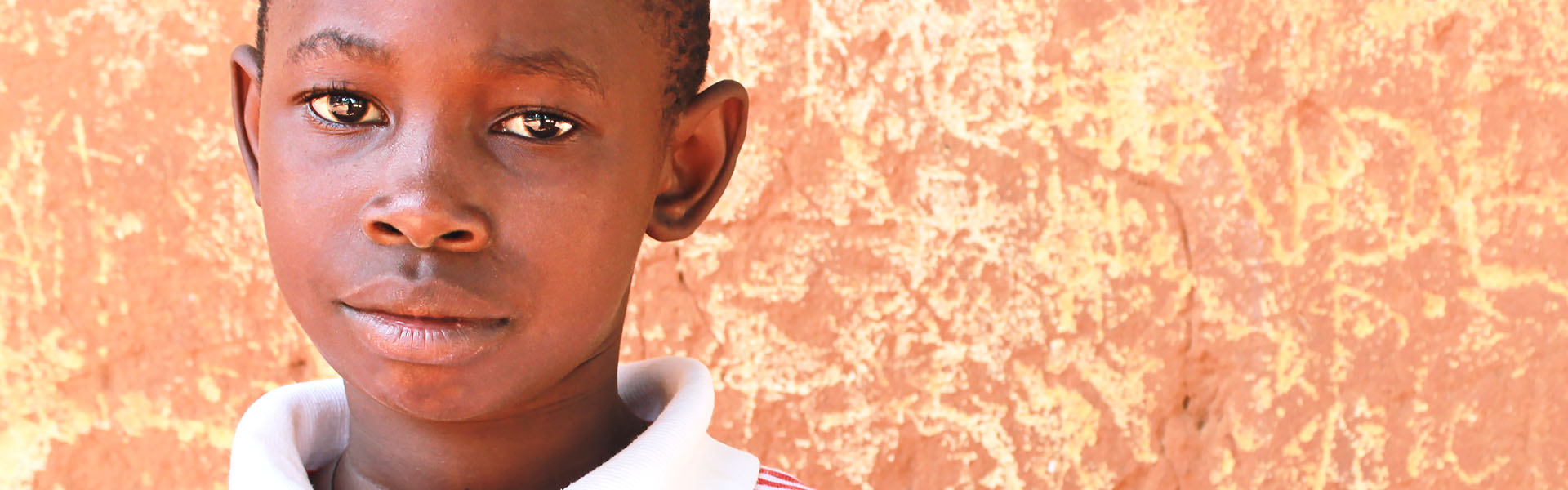 A child in Tanzania standing in front of a abstract background