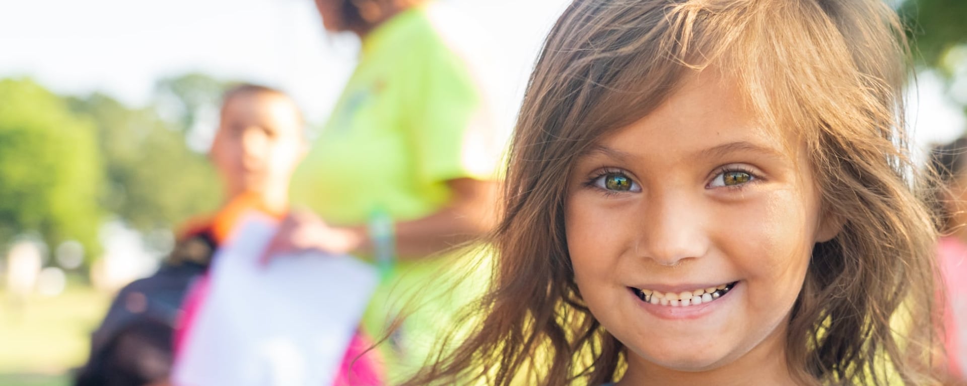 A girl smiling outdoors at an event