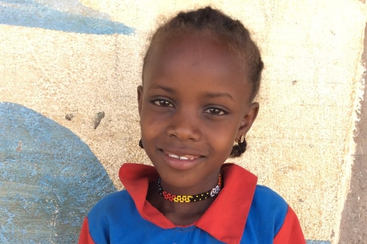 A child in Kenya outdoors smiling
