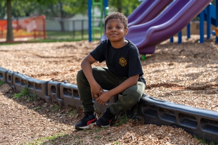 A child sitting outdoors at a playground