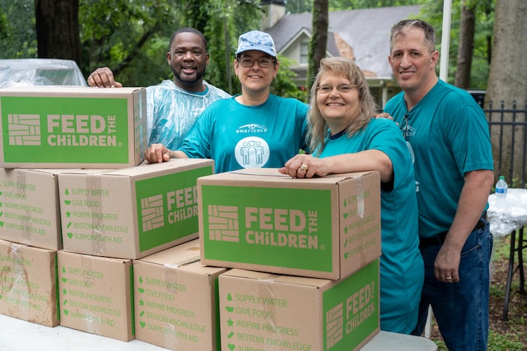 Volunteers at an event with Feed the Children boxes
