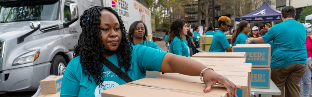 Volunteers carrying boxes at an event