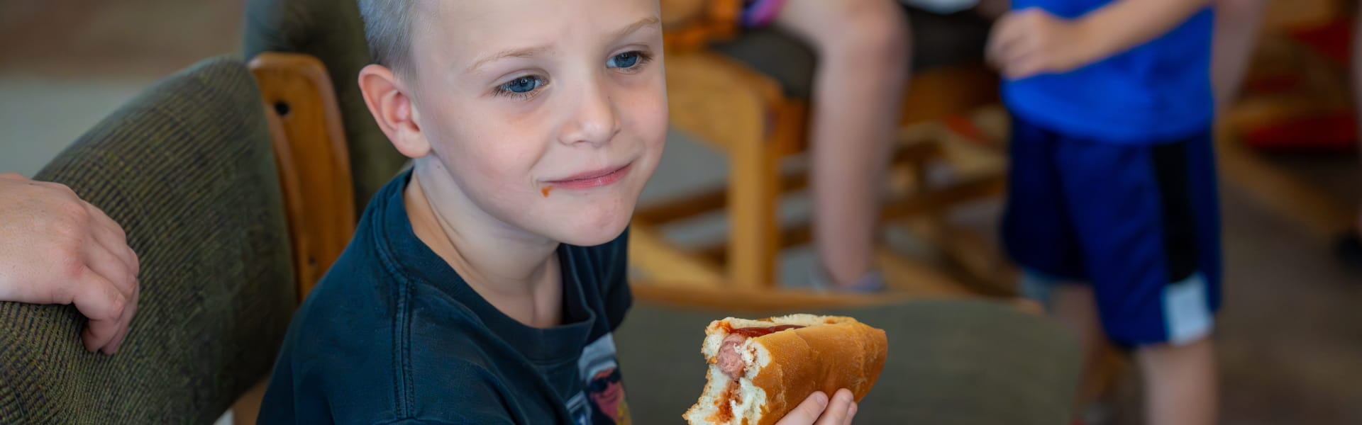 A Child eating food while sitting in a chair