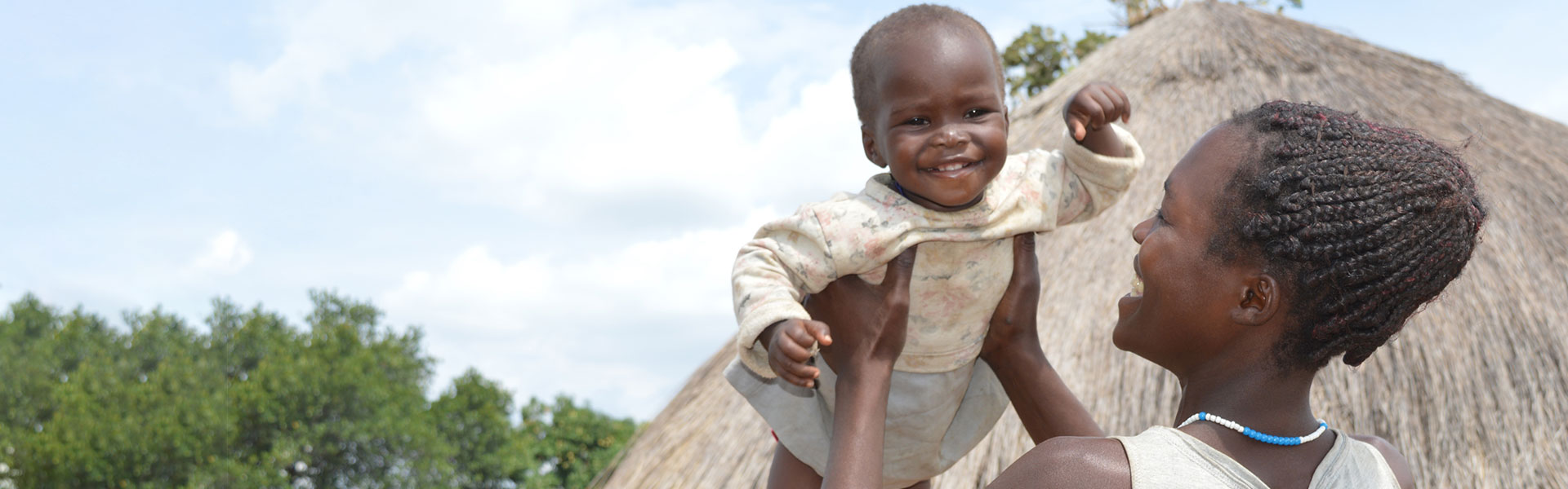 A mother holding her child up while outdoors