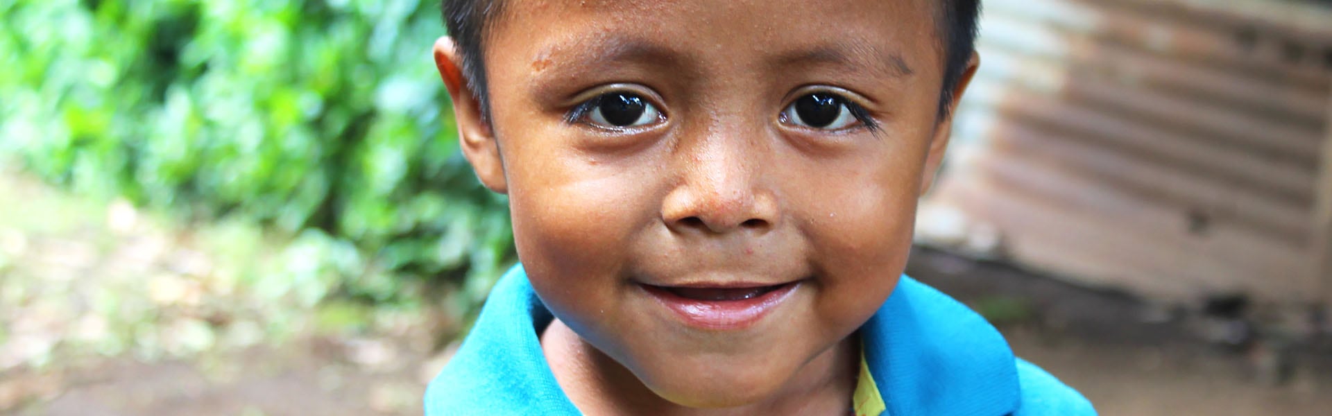 A boy smiling outdoors in El Salvador