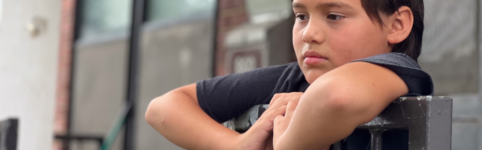 A child leaning over a railing outdoors