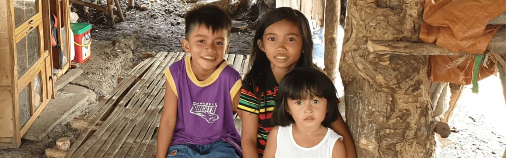 Three children sitting on the ground