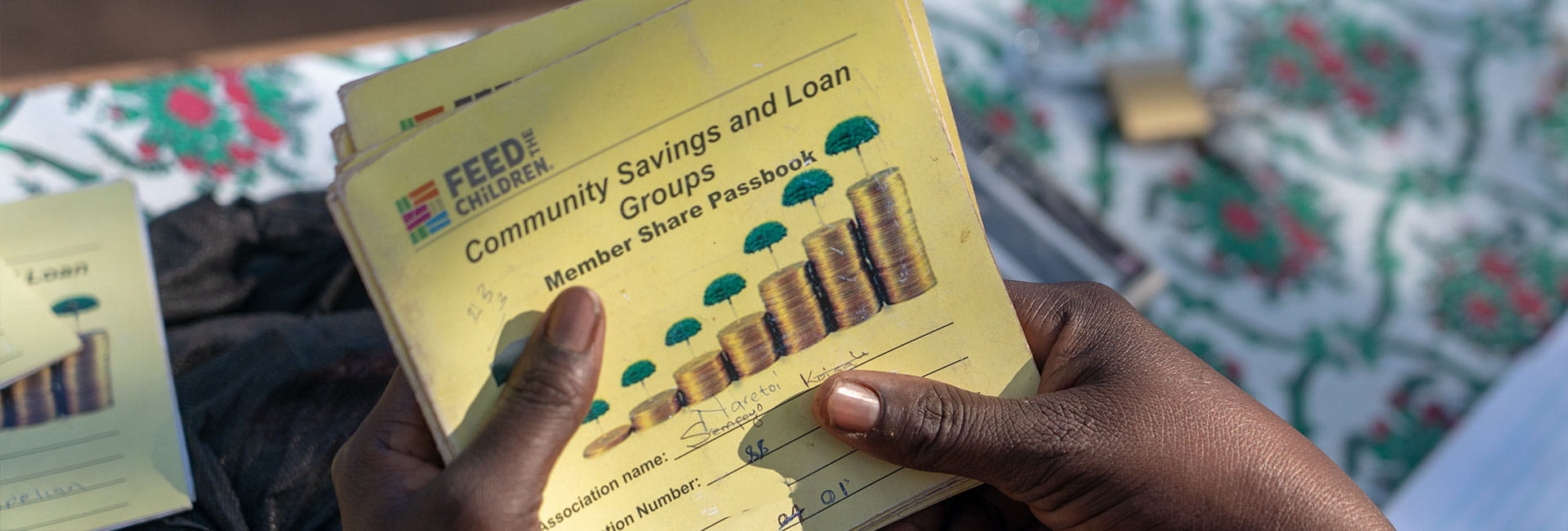 A person holding a pamphlet about the feed the children community savings and loan groups