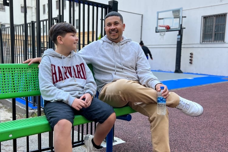 Marco sitting with his son outdoors