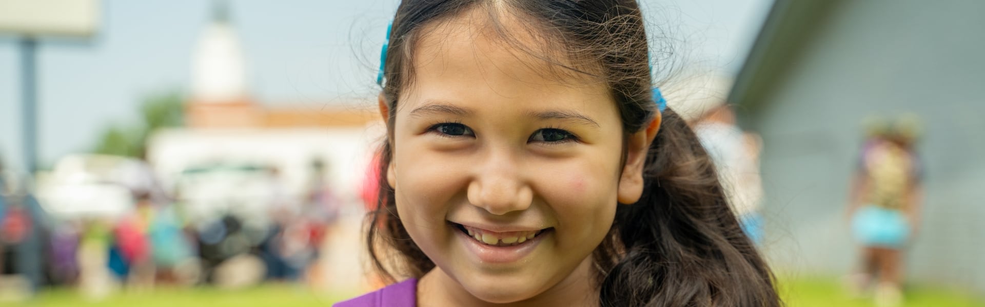 A child smiling while outdoors at an event