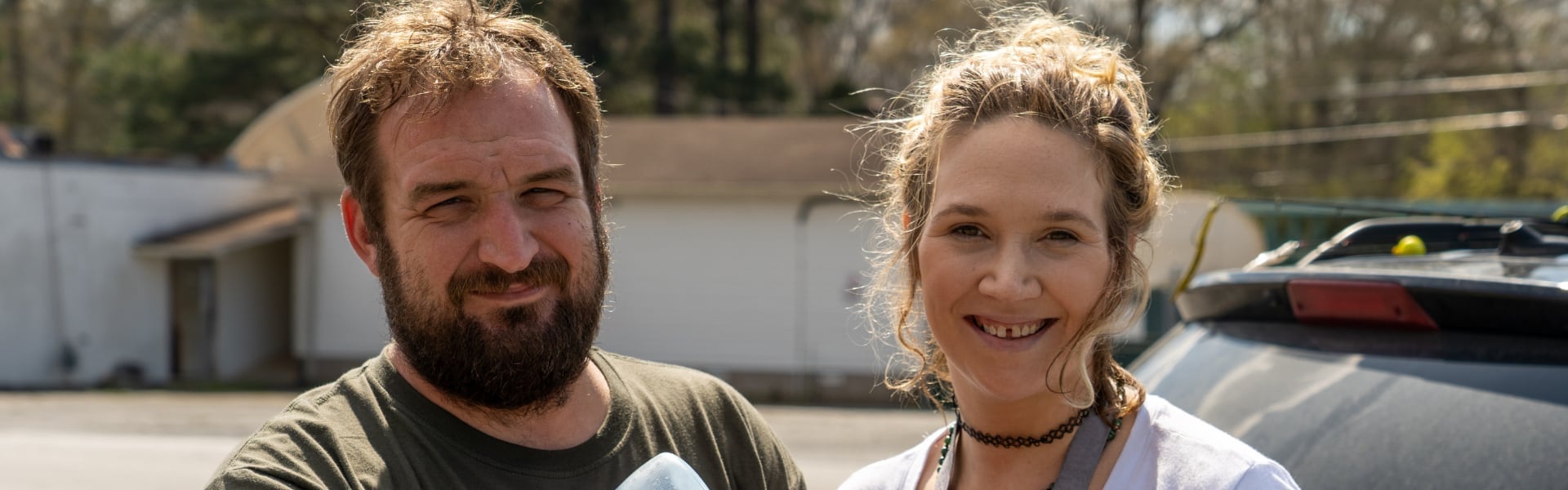 A man and woman smiling outdoors