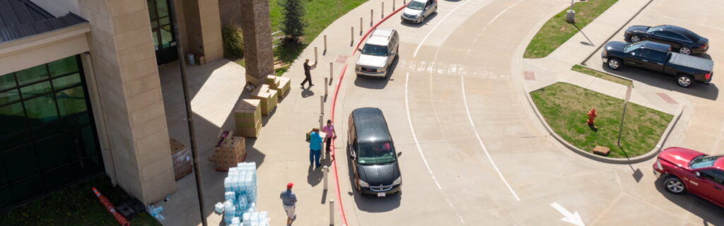 A line of vehicles getting boxes of supplies