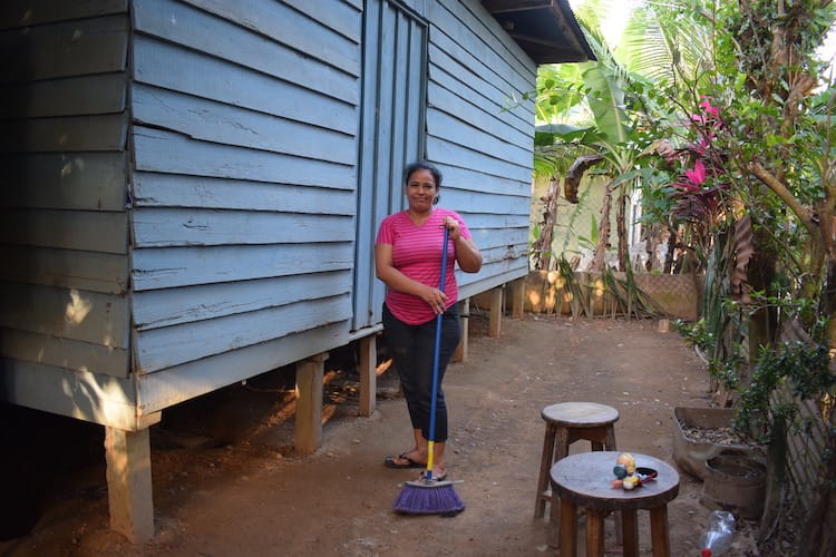 A woman sweeping with a broom outdoors