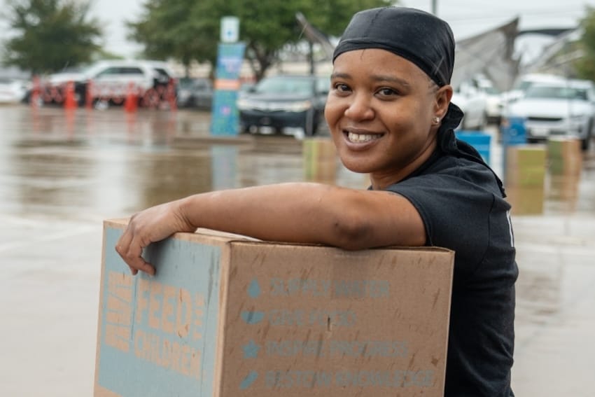 A person holding a feed the children box at an event