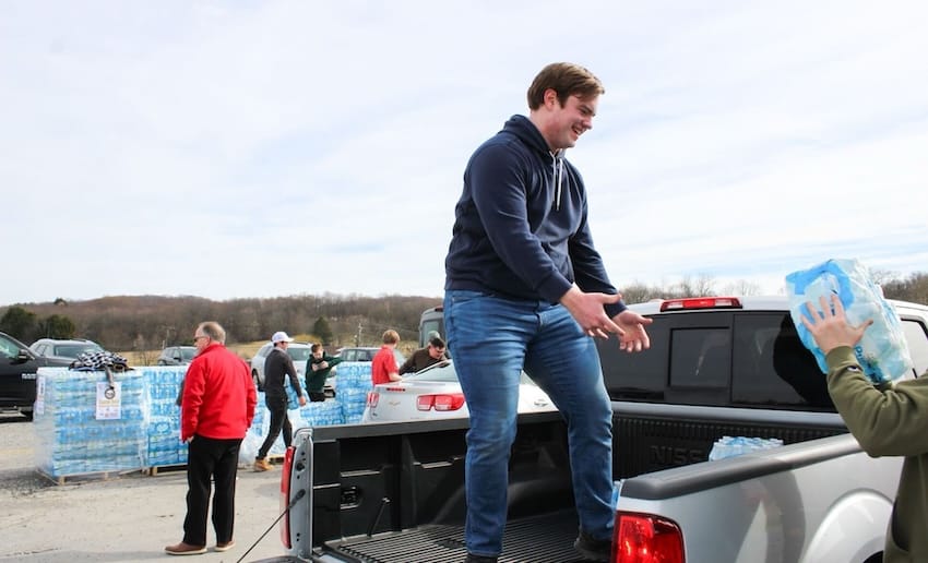 A volunteer standing in the bed of a pickup truck