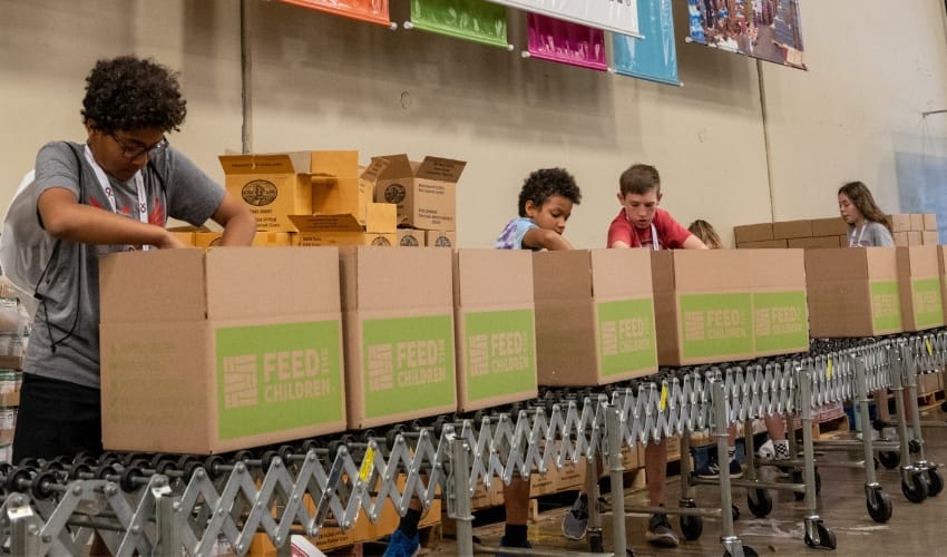 A group of volunteers filling boxes in a warehouse