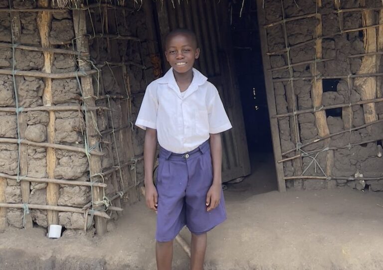 A child standing outside a house in Africa