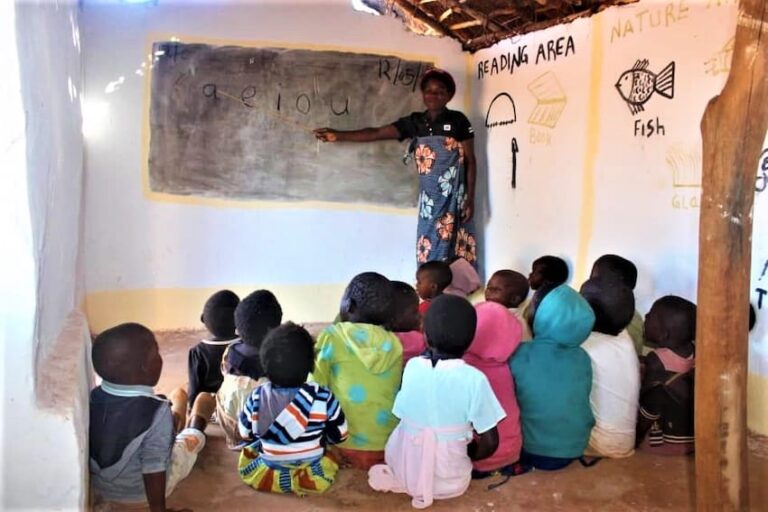 A teacher in a classroom teaching children in africa