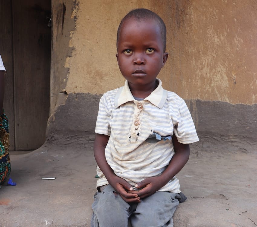 A boy sitting outside in Africa
