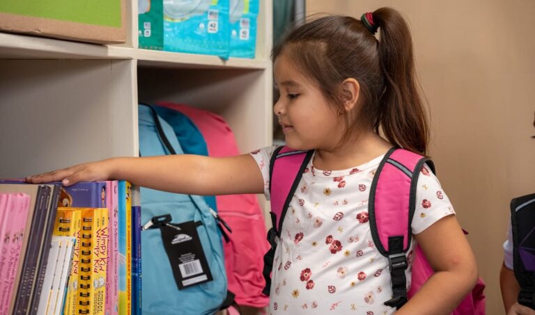 A girl with her hand on books in a school.