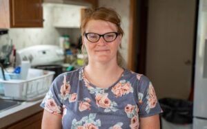 Una mujer sonríe de pie en una cocina