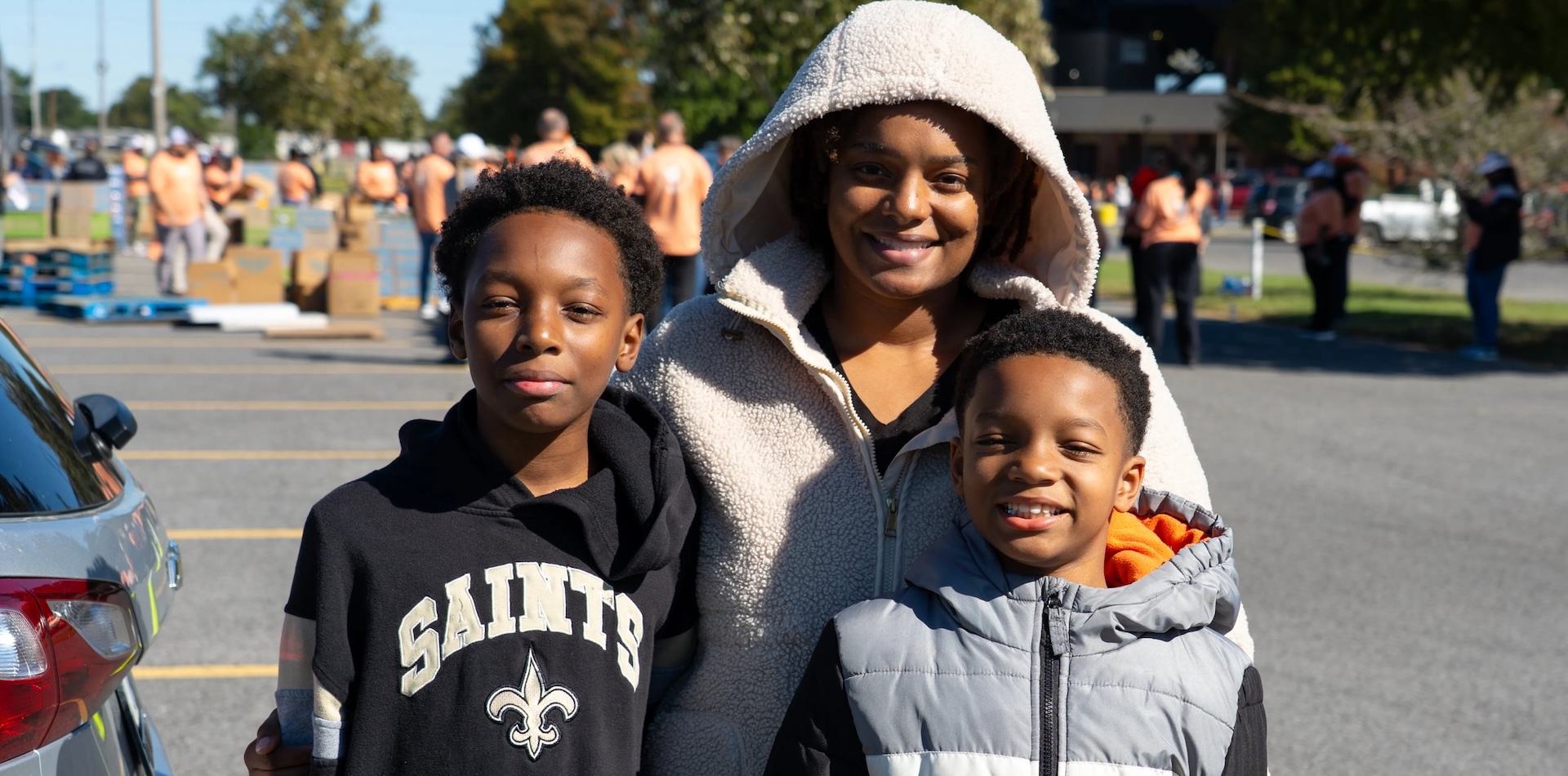 A Woman and two children standing together at an outdoor event.