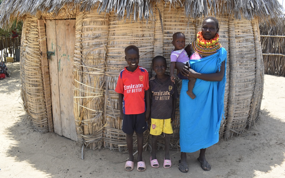 Everline and her children outside a home in Kenya.