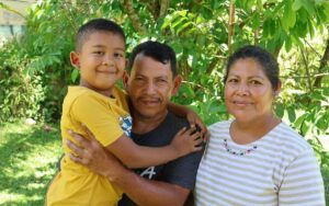Blanca and her husband and son sitting outdoors.