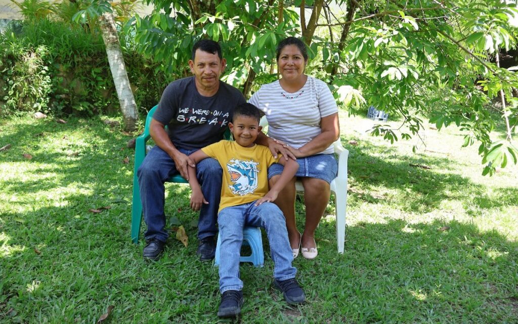 Blancas family sitting in chairs in a yard.