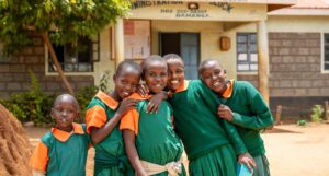 Children standing together in uniforms outside a school.